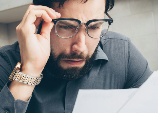 uomo perplesso davanti a dei dati