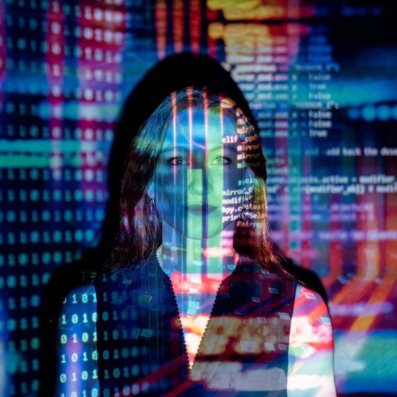 Donna con righe di codice del monitor riflesse sulla facciia