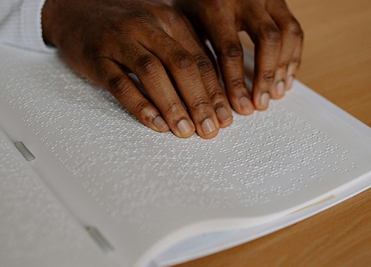 Uomo che legge in Braille