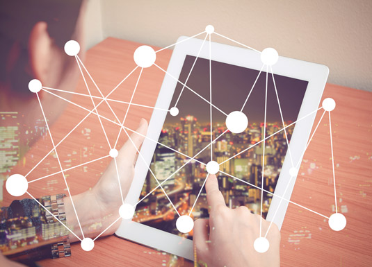 perosna che digita sul tablet e rappresentazione simbolica di una serie di nodi nel web